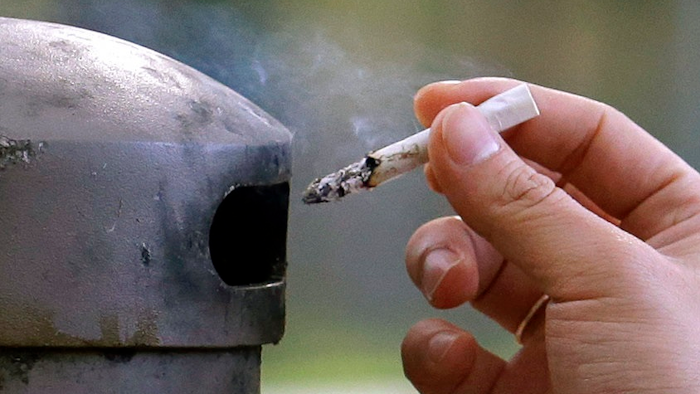 In this Oct. 27, 2015, file photo, a University of Washington student discards a cigarette into a container at a designated smoking locations on the campus in Seattle. Seventeen public health schools in the U.S. and Canada have pledged to refuse research money from a new anti-smoking group funded by the tobacco industry. Deans of public health schools at Harvard, Johns Hopkins and a dozen other schools said Thursday, Jan. 25, 2018, that the group is too closely tied to an industry that sells harmful products.