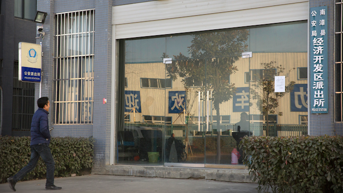 In this Dec. 18, 2017, photo, Chinese labor activist Hua Haifeng walks toward the front door of a local police station as he prepares to do a weekly check-in with officials on the outskirts of Xiangyang in central China's Hubei Province. Apple Inc. and Ivanka Trump's brand both rely on Chinese suppliers that have been criticized for workplace abuses. But they've taken contrasting approaches to dealing with supply chain problems. When Apple learned thousands of student workers at an iPhone supplier had been underpaid, it helped them get their money back. After three men investigating labor abuses at factories that made Ivanka Trump shoes were arrested last year, neither Ivanka Trump nor her brand spoke out.