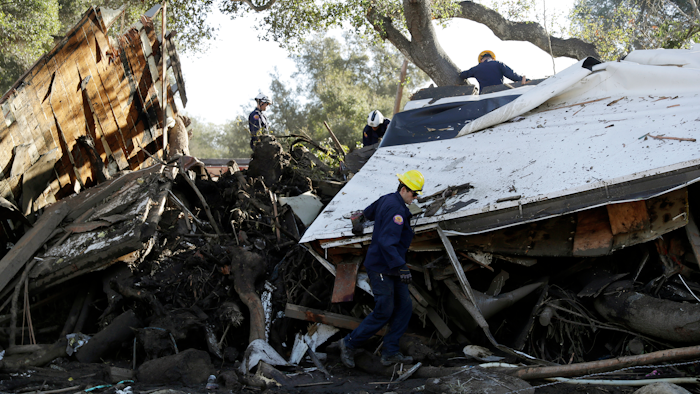 Search and rescue personnel scan a home in the aftermath of a mudslide, Jan. 13, 2018, in Montecito, California.