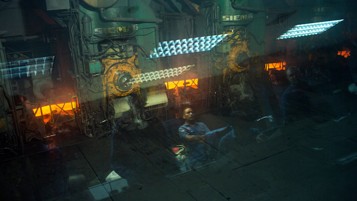 In this Nov. 6, 2017 photo, workers are reflected on a window at the Sidor steel mill, in Ciudad Guayana, Bolivar state, Venezuela. Ciudad Guyana was long seen as the future of Venezuela. U.S. companies in the 1950s zeroed in on Venezuela's vast resources, pouring money into factories for turning iron ore to steel and bauxite for aluminum as well as rails and river ports for shipping it to market.