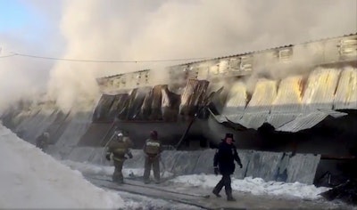 In this Russian Emergency Situations Ministry photo, made available on Thursday, Jan. 4, 2018, Firefighters attend the scene of a fire at a shoe-manufacturing company in the village of Chernoretsky, about 2800 kilometers (1800 miles) east of Moscow, Russia. Russian news reports say at least 10 people have been killed in a warehouse fire in a Siberian village and that the dead are believed to be workers from China and Kyrgyzstan.