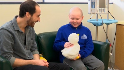 In this undated photo made from video, 12-year-old cancer patient Ethan Daniels at medical facility in Atlanta speaks with Aaron Horowitz, co-founder and CEO of Sproutel, who designed 'My Special Aflac Duck' to promote emotional well-being by helping children living with cancer develop a sense of control and manage stress through interactive technology.