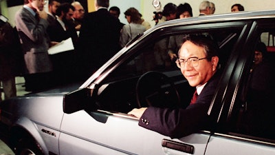 In this Tuesday, Dec. 18, 1984, file photo, United Motor Manufacturing Co. President Tatsuro Toyoda gets in the drivers seat of the newly unveiled sporty 4-door subcompact 'Nova' in the new Fremont, Calif., United Motor Manufacturing Co. plantjointly jowned by General Motors and Toyota. Toyoda, a former president of Toyota Motor Corp., who led its climb to rank among the world’s top automakers, and the son of the Japanese automaker’s founder, has died. He was 88.