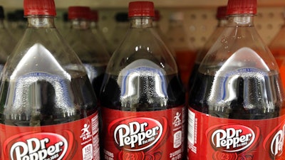 This April 28, 2016, file photo shows bottles of Dr. Pepper on a store shelf at Quality Cash Market in Concord, N.H. Keurig is buying Dr. Pepper Snapple Group Inc. to create a beverage business with approximately $11 billion in annual sales, announced Monday, Jan. 29, 2018.