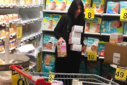 Pharmacist Deborah Cohen removes boxes of baby milk in Paris, Thursday, Dec. 21, 2017. A tainted baby milk scandal affecting some 30 countries is growing, as French dairy giant Lactalis recalled millions more products globally because of fears of salmonella contamination. Lactalis had already recalled several million baby milk products earlier this month.