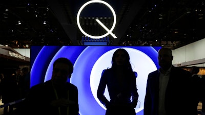 In this Friday, Jan. 6, 2017, file photo, attendees stand in front of a QLED TV at the Samsung booth during CES International in Las Vegas. TV manufacturers are showcasing new models at the 2018 CES gadget show in Las Vegas, all with acronyms to set their sets apart and get consumers to spend more.