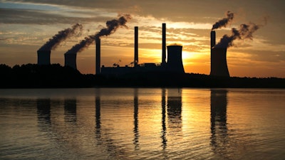 In this June 3, 2017, file photo, the coal-fired Plant Scherer in Juliette, Ga. The Trump administration is doing away with a decades-old air emissions policy opposed by fossil fuel companies, a move that environmental groups say will result in more pollution. The Environmental Protection Agency issued notice Thursday it is withdrawing the “once-in always-in” policy under the Clean Air Act, which dictated how major sources of hazardous air pollutants are regulated.