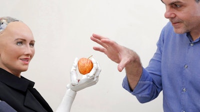In this Sept. 28, 2017, photo, David Hanson, the founder of Hanson Robotics, poses with his company's flagship robot Sophia, a lifelike robot powered by artificial intelligence in Hong Kong. Sophia is a creation of the Hong Kong-based startup working on bringing humanoid robots to the marketplace. Hanson envisions a future in which AI-powered robots evolve to become “super-intelligent genius machines” that can help solve mankind’s most challenging problems.