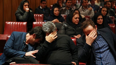 Friends and colleagues of the deceased Iranian seafarers aboard a tanker that sank off the coast of China weep at the headquarters of National Iranian Tanker Company, in Tehran, Iran, Sunday, Jan. 14, 2018. The burning Iranian tanker listing for days off the coast of China after a collision with another vessel sank Sunday, with an Iranian official saying there was 'no hope' of survival for the 29 missing sailors onboard.