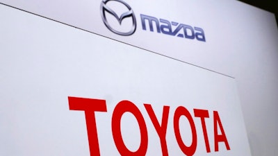 In this Aug. 4, 2017, file photo, logos of Toyota Motor Corp., bottom, and Mazda Motor Corp., top, are placed prior to a news conference in Tokyo. Japanese automakers Toyota and Mazda have picked Alabama as the site of a new $1.6 billion joint-venture auto manufacturing plant, a person briefed on the decision said Tuesday, Jan. 9, 2018.