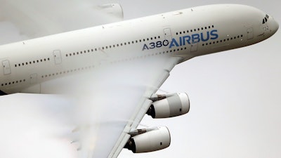 In this June 18 2015 file photo, vapor forms across the wings of an Airbus A380 as it performs a demonstration flight at the Paris Air Show, Le Bourget airport, north of Paris. Emirates airline said in a statement Thursday, Jan. 18, 2018, that they are purchasing 20 A380 aircraft with the option for 16 more in a deal worth $16 billion, throwing a lifeline to the European-made double-decker jumbo jets.