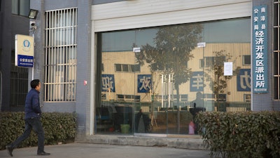 In this Dec. 18, 2017, photo, Chinese labor activist Hua Haifeng walks toward the front door of a local police station as he prepares to do a weekly check-in with officials on the outskirts of Xiangyang in central China's Hubei Province. Apple Inc. and Ivanka Trump's brand both rely on Chinese suppliers that have been criticized for workplace abuses. But they've taken contrasting approaches to dealing with supply chain problems. When Apple learned thousands of student workers at an iPhone supplier had been underpaid, it helped them get their money back. After three men investigating labor abuses at factories that made Ivanka Trump shoes were arrested last year, neither Ivanka Trump nor her brand spoke out.