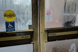 In this Tuesday, Jan. 2, 2018, photo provided by Rebecca Miller, condensation covers an exterior door at Holland Hall on the Tennessee State University campus in Nashville, Tenn. Many office workers find they still have to brave the cold even after they escape the frigid outdoors during the extremely cold winter weather. Miller, an academic adviser at the school, wears sweaters, a scarf, ear coverings, gloves and a blanket over her lap while she works in the building.
