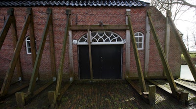 Support beams stabilize an historic farm in Hunzinge, northern Netherlands, Friday, Jan. 19, 2018. More than 3,000 homes in Groningen province are facing reinforcement or even in some cases demolition because of a series of small tremors caused by decades of gas extraction and the Dutch government is being forced to confront the possibility of a future without locally produced gas years earlier than expected.
