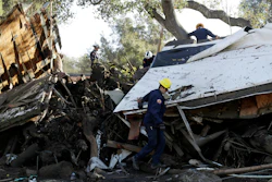 Search and rescue personnel scan a home in the aftermath of a mudslide, Jan. 13, 2018, in Montecito, California.