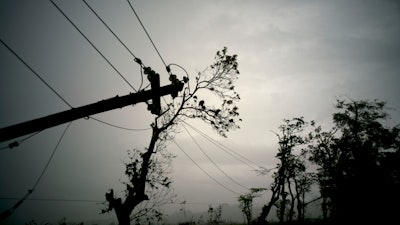 In this Oct. 16, 2017 file photo, power lines lay broken after the passage of Hurricane Maria in Dorado, Puerto Rico. Federal officials said on Monday, Jan. 8 2018, that efforts to fully restore power to Puerto Rico in the wake of Hurricane Maria should get a boost with more work crews and more equipment in upcoming weeks.