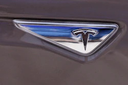 This April 7, 2015 file photo shows the Tesla logo on the new Tesla Model S 70D during a test drive in Detroit. Tesla says it’s put together a 10-year compensation package for CEO Elon Musk that pays him based on certain market cap and operational milestones he hits - otherwise he gets nothing. The electric vehicle maker says Tuesday, Jan. 23, 2018, its market cap would have to grow to $650B for Musk to fully vest.