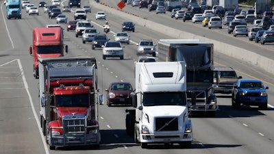 In this Aug. 24, 2016, file photo, truck and automobile traffic mix on Interstate 5, headed north through Fife, Wash., near the Port of Tacoma. President Donald Trump’s plan to beef up the nation’s infrastructure will contain a crater-sized hole when it’s unveiled next month. The trust fund that pays for most federal highway and transit aid is forecast to go broke in about three years unless the government significantly scales back its transportation spending or comes up with more money.