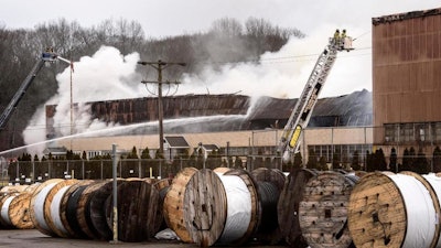 Fire officials work a fire at a Willimantic Waste Paper Co., Inc. building at 1590 West Main Street Sunday, Jan. 28, 2018, in Willimantic, Conn. Fire officials say several departments are on the scene east of Hartford.