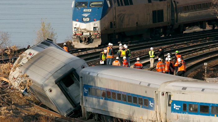 In a Dec. 1, 2013, file photo, an Amtrak train, top, traveling on an unaffected track, passes a derailed Metro North commuter train, in the Bronx borough of New York. President Donald Trump is putting the brakes on attempts to address dangerous transportation safety problems from speeding tractor-trailers to sleepy railroad engineers as part of his quest to roll back regulations across the government.