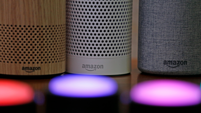 In this Sept. 27, 2017, file photo, Amazon Echo and Echo Plus devices, behind, sit near illuminated Echo Button devices during an event announcing several new Amazon products by the company in Seattle. Amazon is expanding its home-security business by buying Ring, the maker of Wi-Fi-connected doorbells. The deal comes months after the online retailer started selling its own Wi-Fi-connected indoor security cameras, which work with its voice-assistant Alexa.