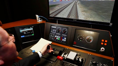 In a Feb. 20, 2014 file photo, Metrolink Director of Operations, R.T. McCarthy, demonstrates Metrolink's implementation of Positive Train Control, (PTC) at the Metrolink Locomotive and Cab Car Simulators training facility in Los Angeles' Union Station. Amtrak is considering suspending service on tracks that don't have sophisticated speed controls by a Dec. 31, 2018 deadline, Amtrak president and CEO Richard Anderson said Feb. 15, 2018, threatening to disrupt operations across the U.S. as it pushes to strengthen safety after a series of deadly wrecks.