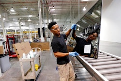In this June 15, 2016, photo, Ricky Foster gingerly carries a completed solar panel to a shipping case after inspecting and cleaning its surface at Stion, a solar panel maker in Hattiesburg, Miss. On Thursday, Feb. 15, 2018, the Federal Reserve reports on U.S. industrial production for January.