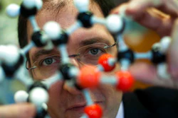 In this Feb. 1, 2012 file photo, Prof. Peter Seeberger, a former Massachusetts Institute of Technology professor poses with a molecule model at his laboratory in Berlin, Germany. Scientists in Germany who developed a new way to make a key malaria drug several years ago said Wednesday Feb. 21, 2018 they have come up with a technique to make the process even more efficient, which should increase global access and reduce the cost. “This development has the potentiation to save millions of lives by increasing the global access and reducing the cost of anti-malaria medicine,” Peter Seeberger, director of the Max Planck Institute unit working on the issue.