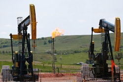 In this June 12, 2014 file photo, oil pumps and natural gas burn off in Watford City, N.D. The Interior Department says it is replacing an Obama-era regulation aimed at restricting harmful methane emissions from oil and gas production on federal lands. A rule being published in the Federal Register this week will replace the 2016 rule with requirements similar to those that were in force before the Obama administration changed the regulation.