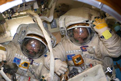 This Jan. 31, 2018 photo made available by NASA shows cosmonauts Alexander Misurkin, left, and Anton Shkaplerov in their Russian Orlan spacesuits during a fit check inside the International Space Station. On Friday, Feb. 2, 2018, the two removed an old electronics box as part of an antenna upgrade at the ISS, then tossed it overboard as a piece of junk.