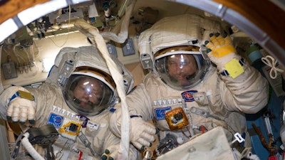This Jan. 31, 2018 photo made available by NASA shows cosmonauts Alexander Misurkin, left, and Anton Shkaplerov in their Russian Orlan spacesuits during a fit check inside the International Space Station. On Friday, Feb. 2, 2018, the two removed an old electronics box as part of an antenna upgrade at the ISS, then tossed it overboard as a piece of junk.