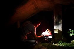 In this Dec. 21, 2017 file photo, barrio Patron resident Karina Santiago Gonzalez works on a small power plant in Morovis, Puerto Rico. A federal control board requested on Friday, Feb. 6, 2018, $300 million loan for Puerto Rico's power company after a federal judge rejected a previous $1 billion loan request despite warnings the U.S. territory would have to start rationing electricity. Some 400,000 customers remain in the dark five months after Hurricane Maria.