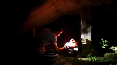 In this Dec. 21, 2017 file photo, barrio Patron resident Karina Santiago Gonzalez works on a small power plant in Morovis, Puerto Rico. A federal control board requested on Friday, Feb. 6, 2018, $300 million loan for Puerto Rico's power company after a federal judge rejected a previous $1 billion loan request despite warnings the U.S. territory would have to start rationing electricity. Some 400,000 customers remain in the dark five months after Hurricane Maria.