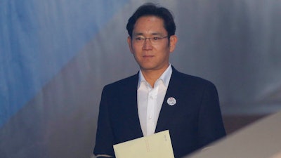 Lee Jae-yong, center, vice chairman of Samsung Electronics, arrives at the Seoul High Court for a hearing in Seoul, South Korea, Monday, Feb. 5, 2018. The court handed down a 2 ½ year suspended jail sentence for corruption to Samsung’s billionaire heir Lee. Lee, the only son of Samsung’s ailing chairman, was given a five-year prison term in August on bribery and other charges linked to a political scandal that took down former South Korean President Park Geun-hye.