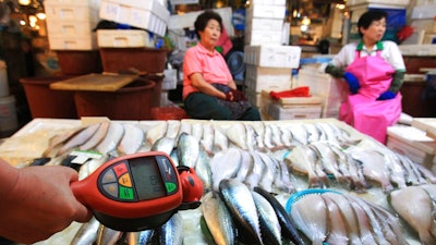 In this Sept. 6, 2013, file photo, a worker using a Geiger counter checks for possible radioactive contamination at Noryangjin Fisheries Wholesale Market in Seoul, South Korea. South Korea said Friday, Feb. 23, 2018, it will appeal the World Trade Organization's decision against Seoul's import bans on Japanese fishery products imposed in the wake of Fukushima nuclear meltdowns.