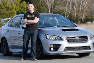 In this Friday, Feb. 9, 2018, photo, Jonathan Cypert stands in front of his wife's 2017 Subaru Impreza, in Virginia, that he purchased with bitcoins he acquired in 2011. Cypert sees his bitcoin cache as a nest egg to tide him over after he retires from the military.
