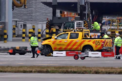 Emergency personnel attend to one of the vehicles involved in a crash at Heathrow Airport, London on Wednesday Feb. 14, 2018. London's Heathrow Airport says two men have been injured after a 'serious accident involving two vehicles' on the airfield. The airport says it is working with police to investigate the accident, which did not involve any passengers.