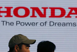 In this April 28, 2017, file photo, visitors walk through a showroom of the Honda Motor Co. headquarters in Tokyo. Honda Motor Co.'s profit for the fiscal third quarter has more than tripled what the Japanese automaker earned in 2017 as its sales grew and profits got a perk from a U.S. tax cut.