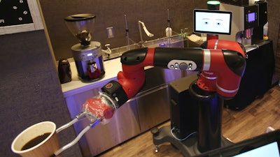 Robot barista named 'Sawyer' makes a coffee at Henn-na Cafe, Japanese meaning 'Strange Cafe'in Tokyo, Friday, Feb. 2, 2018. The cafe's robot barista brews and serves coffee as the rapidly aging country seeks to adapt to shrinking workforce. The arm robot 'Sawyer' debuted this week in Tokyo‘s downtown business and shopping district of Shibuya.