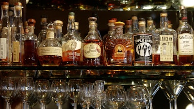 This Oct. 23, 2014 file photo shows a selection of Whiskeys displayed in New York. American whiskey makers are toasting another round of robust sales in 2017. A report shows the growth was stirred by a thirst for the priciest spirits, in cocktails or sipped straight up. The Distilled Spirits Council said Thursday, Feb. 1, 2018, that demand grew in the U.S. and overseas as the spirits industry gained market share in the crowded domestic adult beverage sector.