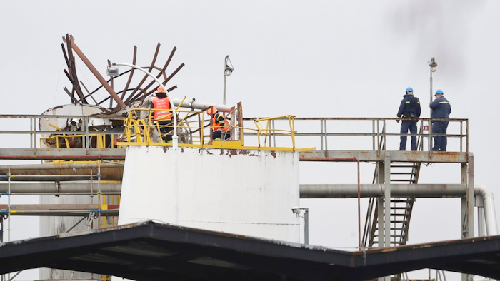 People stand the site of an explosion in a chemical plant in Kralupy nad Vltavou, Czech Republic, Thursday, March 22, 2018. Vladimira Kerekova, spokeswoman for the regional firefighters, says an explosion in a chemical factory, north of Prague, the Czech Republic has killed six people and injured an unspecified number.