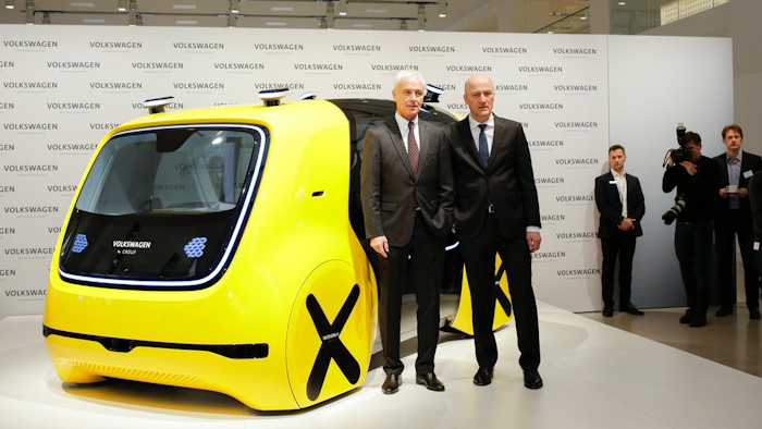 VW group CEO Matthias Mueller, left, and CFO Frank Witter, right, pose in front of a self driving concept car prior to the annual media conference of the Volkswagen group, in Berlin, Germany, Tuesday, March 13, 2018.
