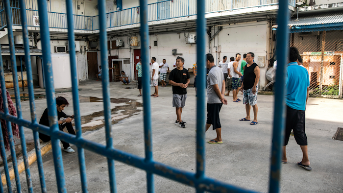 In this July 26, 2017 photo, Chinese laborers at the Imperial Pacific Casino gather in front of their living quarters before a protest in Saipan, the Northern Mariana Islands, a U.S. commonwealth in the Western Pacific. Foreign workers at Chinese construction firms building the casino are still waiting to be paid their wages. U.S. officials announced $14 million in settlements last week with the companies after finding workers were paid less than required by law. But hundreds of workers remain confused about what's owed and how they'll be paid.
