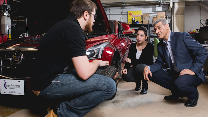 This is a photo of new valve technology that promises cheaper, greener engines, Amir Khajepour, a professor of mechanical and mechatronics engineering at Waterloo, in his lab working with his students.