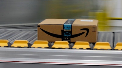 In this Feb. 9, 2018, file photo, a box for an Amazon prime customer moves through the new Amazon Fulfillment Center in Sacramento, Calif. President Donald Trump took another shot at Amazon.com on Thursday, March 29, tweeting that the online retailer pays “little or no taxes” and that it uses the U.S. Post Service as a “Delivery Boy.”