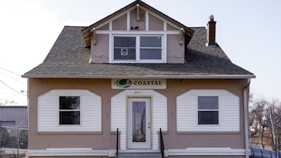 A Coastal Environment Group sign hangs Wednesday, March 21, 2018, on the front of a building registered as the offices of SWF Constructors in Omaha, Neb. Federal officials are saying little about how they chose SWF Constructors, a Nebraska startup to build an $11 million section of border wall in California, including whether they knew of the company’s connections to a construction firm flagged in a government audit for “many potential fraud indicators.”