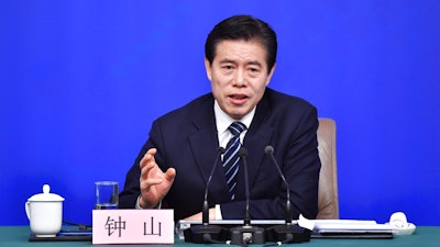 In this photo released by China's Xinhua News Agency, Chinese Minister of Commerce Zhong Shan speaks at a press conference in Beijing, Sunday, March 11, 2018. China says it will not initiate a 'disastrous' trade war with the United States, but is vowing to defend its national interests in the face of growing American protectionism.