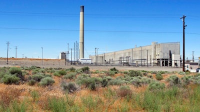 In this file photo taken June 13, 2017, the Plutonium Uranium Extraction Plant, right, stands adjacent to a dirt-covered rail tunnel, left, containing radioactive waste, amidst desert plants on the Hanford Nuclear Reservation near Richland, Wash. A new report says mistakes and mismanagement are to blame for the exposure of workers at the Hanford Nuclear Reservation in Washington state to radioactive particles in December.