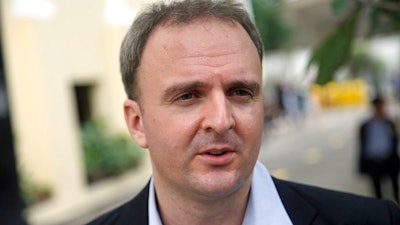 In this Nov. 3, 2016, file photo, British labor rights activist Andy Hall talks to reporters at the Supreme Court in Bangkok. A court in the Thai capital has ordered the activist to pay 10 million baht ($321,000) in damages to a company that filed a civil defamation suit after he helped expose alleged human rights violations at its factory. The Monday, March 26, 2018 ruling against Hall was just the latest development involving one of four defamation suits filed by pineapple canning company Natural Fruit, which employed migrant Myanmar workers who claimed the company had broken labor regulations in abusing them.