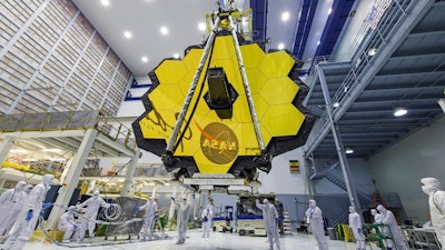 In this April 13, 2017 photo provided by NASA, technicians lift the mirror of the James Webb Space Telescope using a crane at the Goddard Space Flight Center in Greenbelt, Md. The telescope’s 18-segmented gold mirror is specially designed to capture infrared light from the first galaxies that formed in the early universe. On Tuesday, March 27, 2018, NASA announced it has delayed the launch of the next-generation space telescope until 2020.